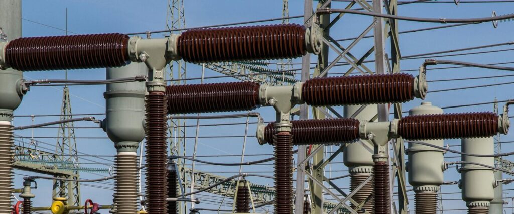Detailed view of high voltage electrical substation with transformers and power lines.